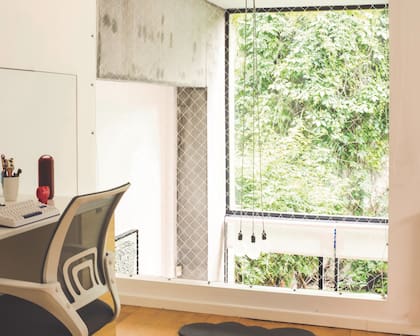 Doble altura que balconea al living, y mira a una blanda medianera verde gracias a los ventanales altísimos.