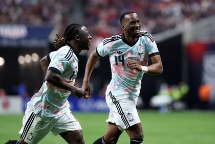 Dodi Lukebakio festeja uno de sus dos goles, seguido por Jeremy Doku