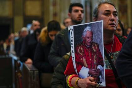 Dolientes hacen fila en la Basílica de San Pedro para dar un último adios al fallecido papa emérito Benedicto XVI, el miércoles 4 de enero de 2023, en el Vaticano. (AP Foto/Antonio Calanni)