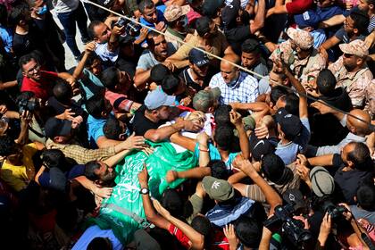 Dolientes palestinos llevan el cuerpo de Osama Dueij, de 32 años, herido de bala en una protesta violenta en la frontera de Gaza con Israel, durante su funeral el miércoles, 25 de agosto del 2021. (AP Foto/Adel Hana)