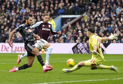 Dominic Calvert-Lewin busca definir por encima de Dibu Martínez, pero el arquero marplatense logra bloquear la definición del jugador del Leeds; Aston Villa rescató un empate sobre el final del partido