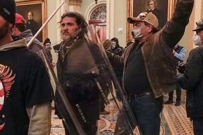 Dominic Pezzola, centro con escudo policial, y otros insurrectos enfrentan a agentes de la Policía del Capitolio frente al recinto del Senado en el Capitolio, 6 de enero de 2021. Pezzola, exmiembro de la milicia de ultraderecha Proud Boys que rompió una ventana del Capitolio durante la insurrección, fue condenado a 10 años de prisión el viernes 1 de setiembre de 2023