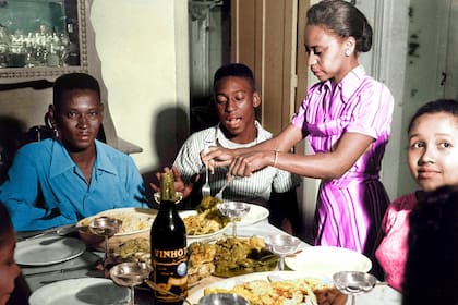 Doña Celeste Arantes sirve pastas en un almuerzo familiar, en el que su marido, João Ramos do Nascimento, ocupa una cabecera de la mesa; Pelé tenía 17 años y ya era campeón mundial en Suecia 1958; mira Maria Lúcia, su hermana.