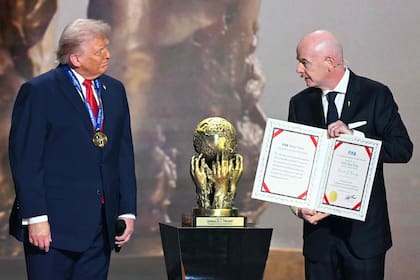Donald Trump recibe el premio de la paz de la FIFA de manos de Gianni Infantino (Photo by Jim WATSON / AFP)