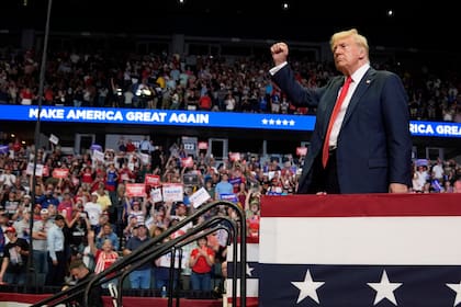 Donald Trump saluda con el puño en alto tras un discurso de campaña en Michigan