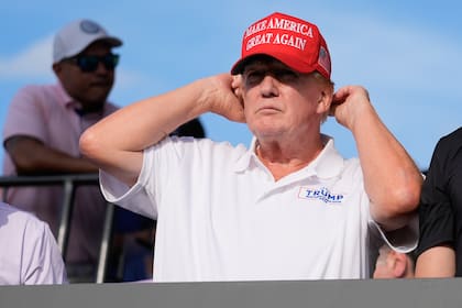 Donald Trump se ajusta la gorra roja con la sigla Make America Great Again
