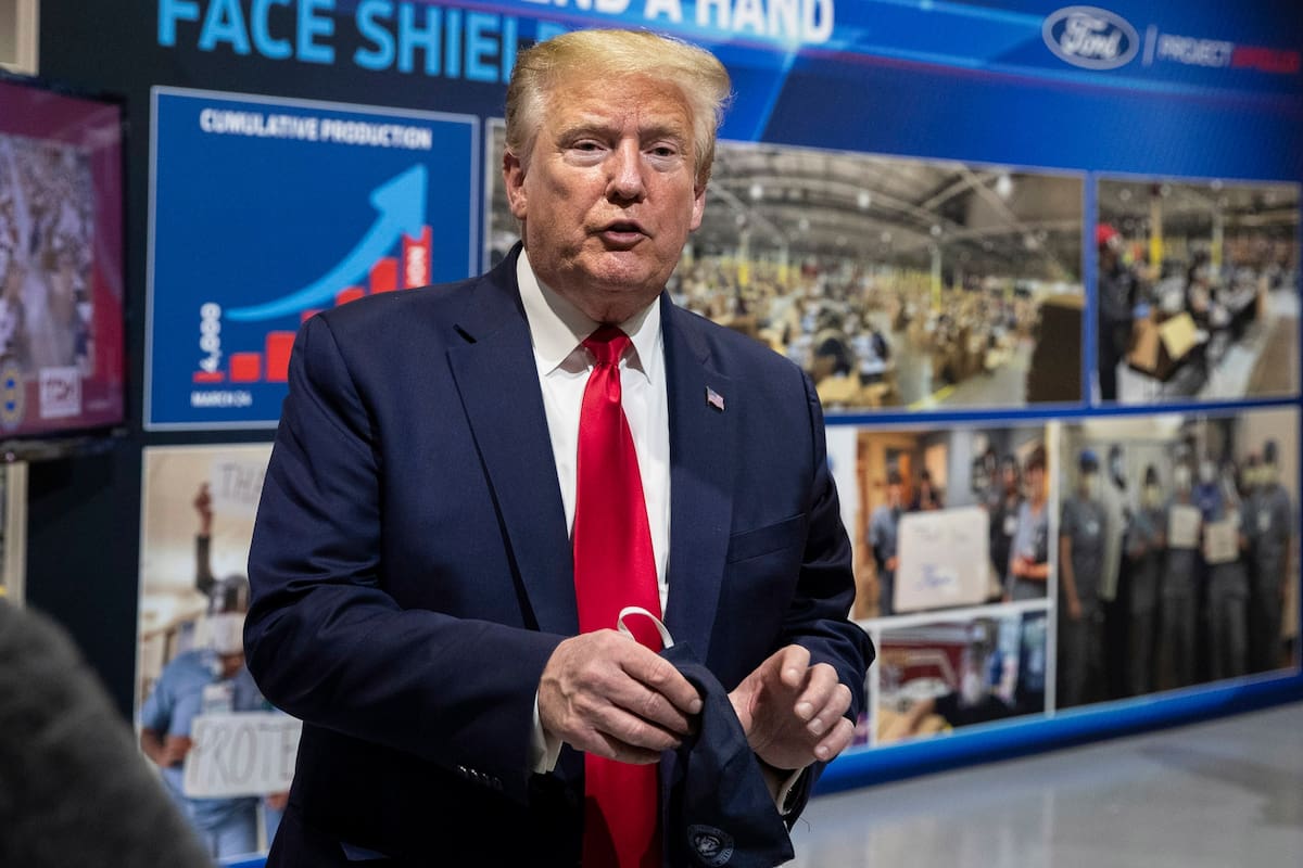 Donald Trump sostiene un barbijo antes de hablar con la prensa