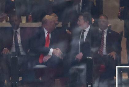 Donald Trump y Elon Musk estrechándose las manos