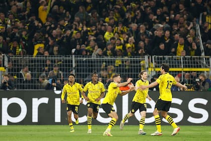 Dortmund's German forward #14 Niclas Fuellkrug (C) celebrates scoring the 3-2 goal with his team-mates during the UEFA Champions League quarter-final second leg football match between Borussia Dortmund and Atletico Madrid in Dortmund, western Germany on April 16, 2024. (Photo by Odd ANDERSEN / AFP)