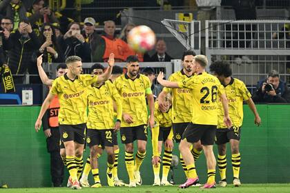 Dortmund's players celebrate after scoring the opening goal during the UEFA Champions League quarter-final second leg football match between Borussia Dortmund and Atletico Madrid in Dortmund, western Germany on April 16, 2024. (Photo by INA FASSBENDER / AFP)