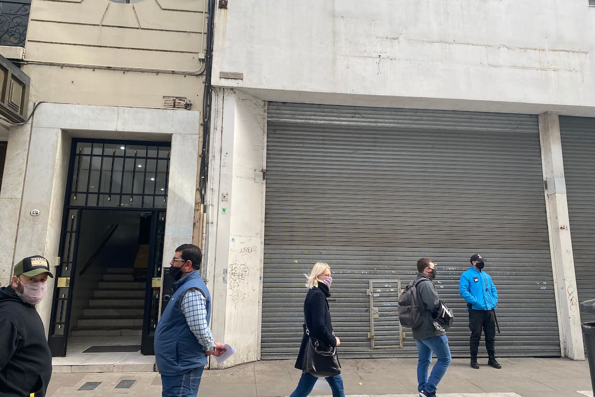 Dos arbolitos, dos peatones y un policía en la calle Florida, casi vacía.