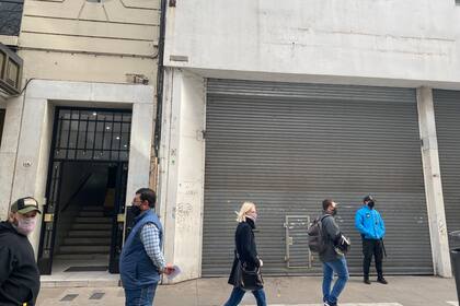 Dos arbolitos, dos peatones y un policía en la calle Florida, casi vacía.
