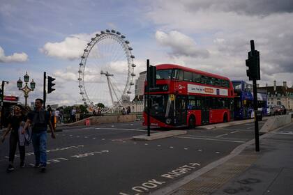 Dos autobuses de dos pisos sobre el puente de Westminster, con el LondonEye al fondo, el viernes 17 de septiembre de 2021, en Londres. (AP Foto/Alberto Pezzali)