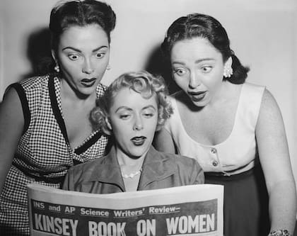 Dos de las cantantes del grupo Barry Sisters y la actriz Barbara Lawrence leyendo sobre el estudio de Kinsey
