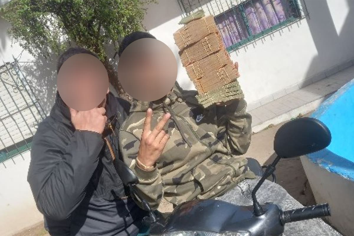Dos de los delincuentes con fajos de dinero que sería parte de un botín