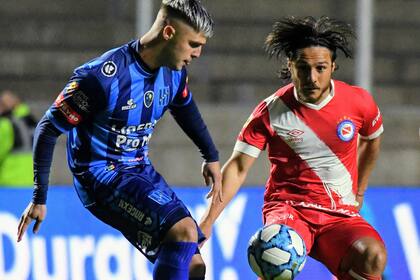 Dos de los goleadores de la noche en San Nicolás: Amilivia lucha por la pelota con Kevin Mac Allister