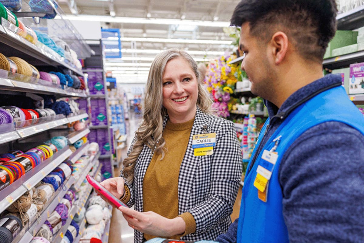Dos empleados de Walmart revisan precios en la app dentro de una tienda. (Archivo)
