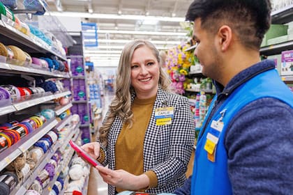 Dos empleados de Walmart revisan precios en la app dentro de una tienda. (Archivo)
