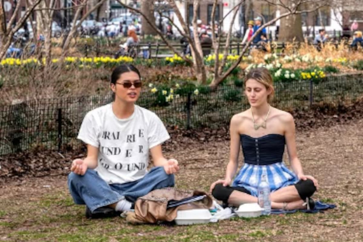 Dos estudiantes en el campus de NYU aprovechan un espacio sin pantallas para conversar y trabajar sin dispositivos digitales