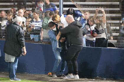 Dos hombres ayudan a una mujer a salir de las tribunas