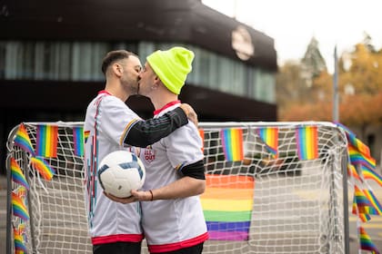 Dos hombres se besan mientras sostienen una pelota de fútbol durante una manifestación para crear conciencia sobre la situación de los derechos humanos de las personas LGBTQ en Qatar y la responsabilidad de la FIFA, frente al Museo de la FIFA en Zúrich, Suiza, el martes 8 de noviembre de 2022. Un embajador de la La Copa de Qatar describió la homosexualidad como un "daño mental". (Michael Buholzer/Keystone vía AP)