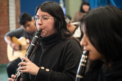Dos jóvenes clarinetistas participan de un ensayo de la Orquesta Ópera Villera, acompañadas por guitarristas del proyecto