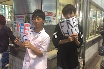Dos jóvenes en Shibuya ofrecen abrazos gratis.