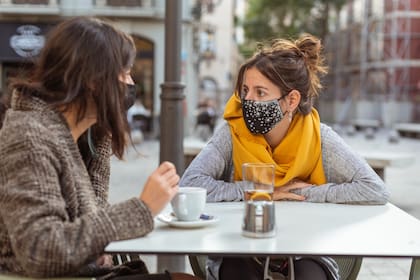 Dos mujeres comparten un café al aire libre en Madrid durante la pandemia de coronavirus