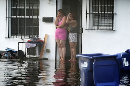 Dos mujeres reaccionan al ver inundaciones en su calle