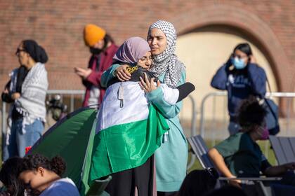 Dos mujeres se abrazan mientras estudiantes del Instituto de Tecnología de Massachusetts, la Universidad de Harvard y otros se manifiestan en un campamento de protesta contra el ataque de Israel a Gaza el 22 de abril de 2024 en Cambridge, Massachusetts.