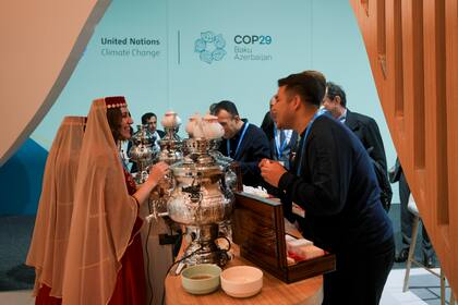 Dos mujeres sirven té en el pabellón de Azerbaiyán durante la cumbre climática COP29 de la ONU, el miércoles 13 de noviembre de 2024, en Bakú, Azerbaiyán. (AP Foto/Peter Dejong)