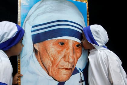 Dos niñas vestidas como Misioneras de la Caridad besan un retrato de la Madre Teresa de Calcuta durante una ceremonia en su honor en Bhopal (India), el de agosto de 2010