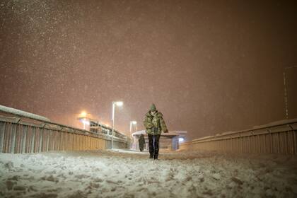 Dos personas caminan bajo una intensa nevada en Estambul, Turquía, el 24 de enero de 2022. (AP Foto/Emrah Gurel)