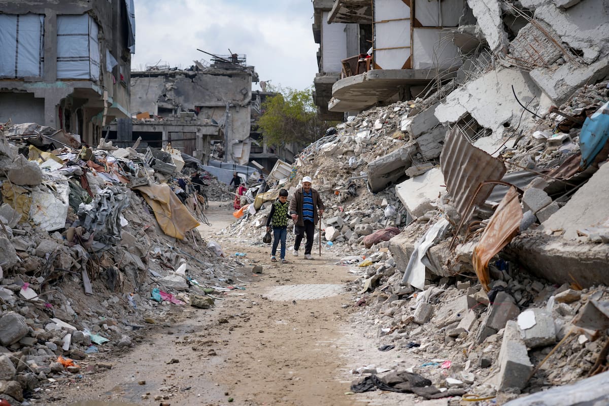 Dos personas caminan entre los escombros de viviendas destruidas por la ofensiva del ejército israelí contra Hamas, en Jabaliya, en el norte de la Franja de Gaza. (AP Foto/Abdel Kareem Hana)