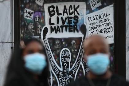 Dos personas con barbijo participan de una protestas en Black Lives Matter Plaza en Washington, DC el 14 de noviembre de 2020