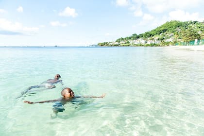 Dos personas disfrutan del agua cristalina de las costas de Grenada