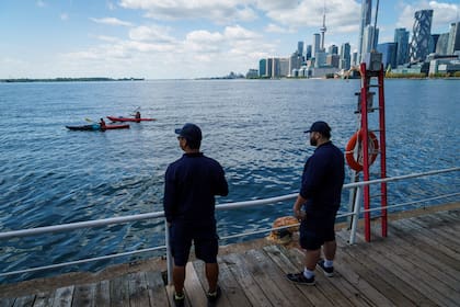Dos personas miran el lago Ontario desde el puerto Toronto