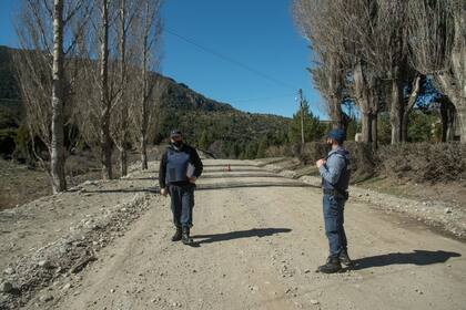 Dos policías junto con una patrulla custodian las cercanías de la propiedad ocupada en Cuesta del Ternero