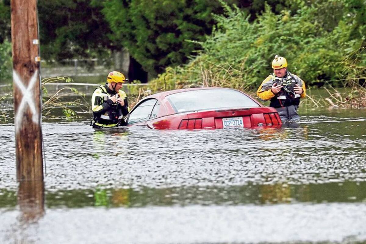 Dos rescatistas revisan un auto en New Bern