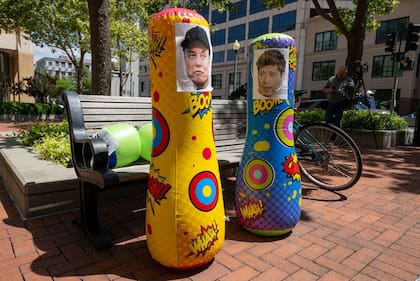 Dos sacos de boxeo inflables con las caras de Elon Musk y Sam Altman a las afueras del tribunal en Oakland, California.