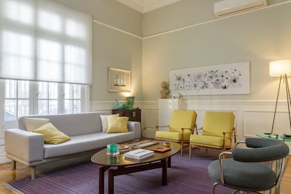 Dos sillones escandinavos (Estudio Grober), un sofá moderno y sillas giratorias de Le Corbusier (Manifesto) configuran el living formal en torno a un kilim de hilo (Bazhars) y una mesa oval de Interieur Forma.