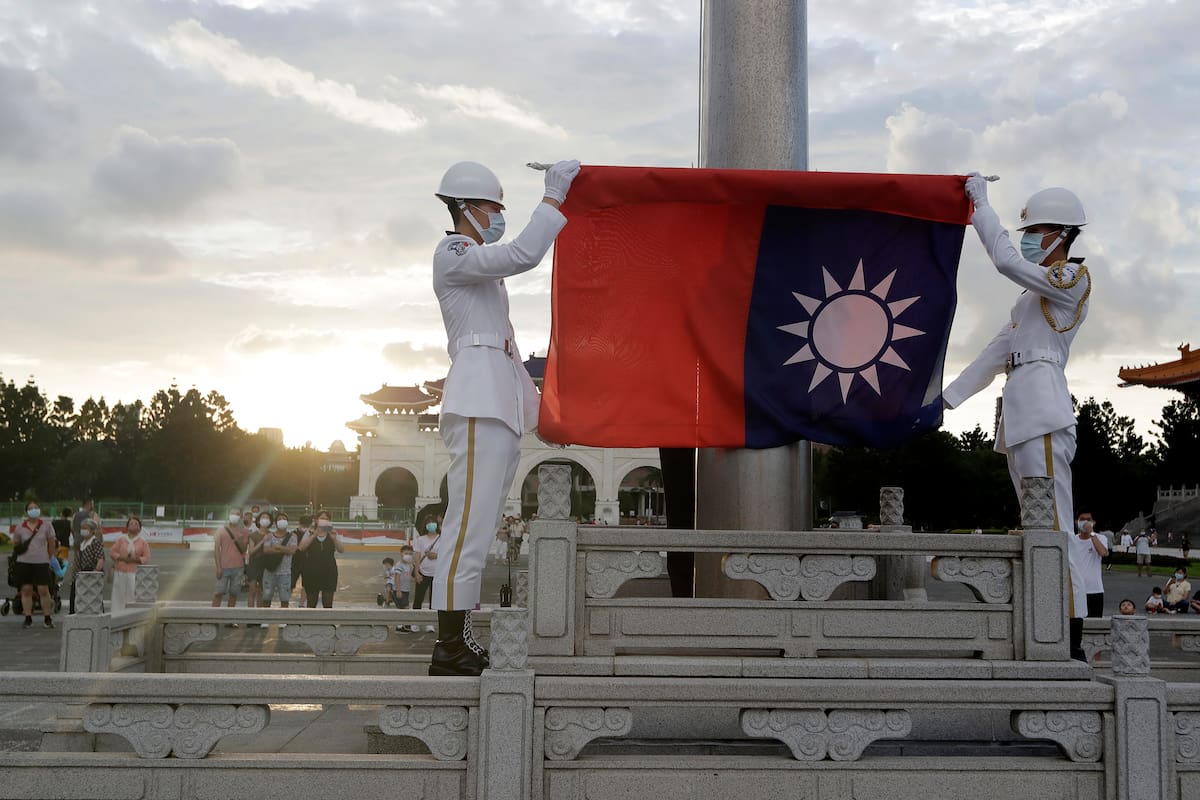 Dos soldados doblan la bandera nacional durante la ceremonia diaria de izado de bandera en la plaza Liberty en Taipéi, Taiwán