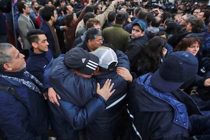 Dos trabajadores despedidos se abrazan al ser desalojados de la fábrica
