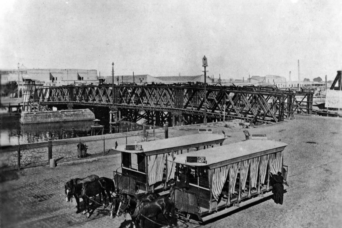 Dos tranvías a caballo frente al antiguo Puente Pueyrredón en Barracas.