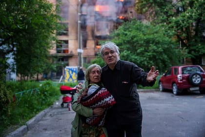 Dos ucranianos miran a su casa destruida tras un ataque ruso en Kiev, el domingo 24 de mayo de 2026. (AP Foto/Evgeniy Maloletka)