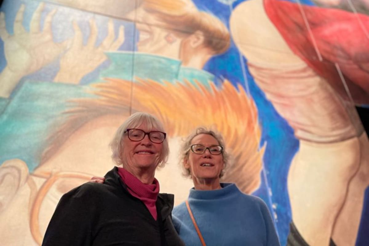 Dottie O'Carroll y Carrie Shoemake quedaron encantadas con lo visto y posan frente a Palace of Winds, de Manfred Deix.