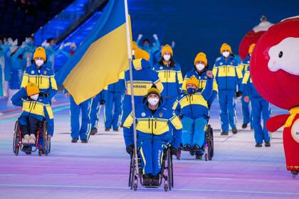 dpatop - 04 March 2022, China, Peking: Paralympics: Opening ceremony in the Olympic Stadium "Bird's Nest". Maksym Yarovyi, flag bearer of Ukraine, enters the stadium with the team from Ukraine during the opening ceremony. The opening ceremony marks the start of the Winter Paralympics in China's capital Beijing. Photo: Jens Büttner/dpa-Zentralbild/dpa (Photo by Jens Büttner/picture alliance via Getty Images)