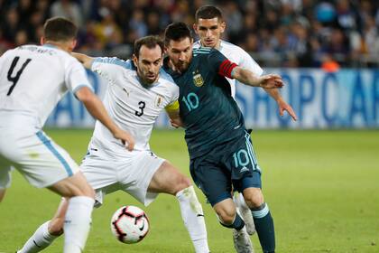 Duelo de fuerza: Diego Godín busca cerrarle el paso a Messi en un amistoso jugado en el Bloomfield Stadium de Tel Aviv en noviembre de 2019