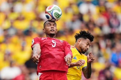Duelo en lo alto: Manuel Akanji (5) despeja ante el ataque del colombiano Luis Suárez (Darryl Dyck/The Canadian Press via AP)