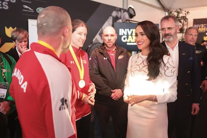 Durante el segundo día de los juegos, la duquesa –con vestido de Valentino de mangas largas, cuello redondo y detalle calado de flores en el escote– conversa con miembros del equipo canadiense que participaron de Invictus.